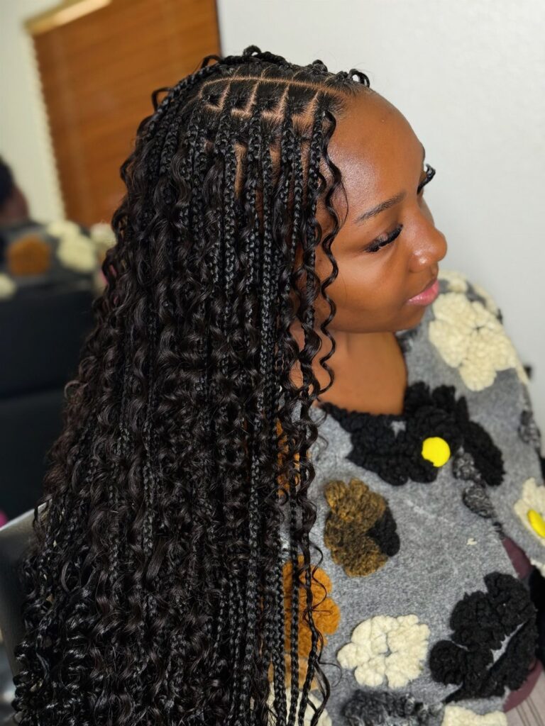 Woman showing long black knotless braids with loose curls