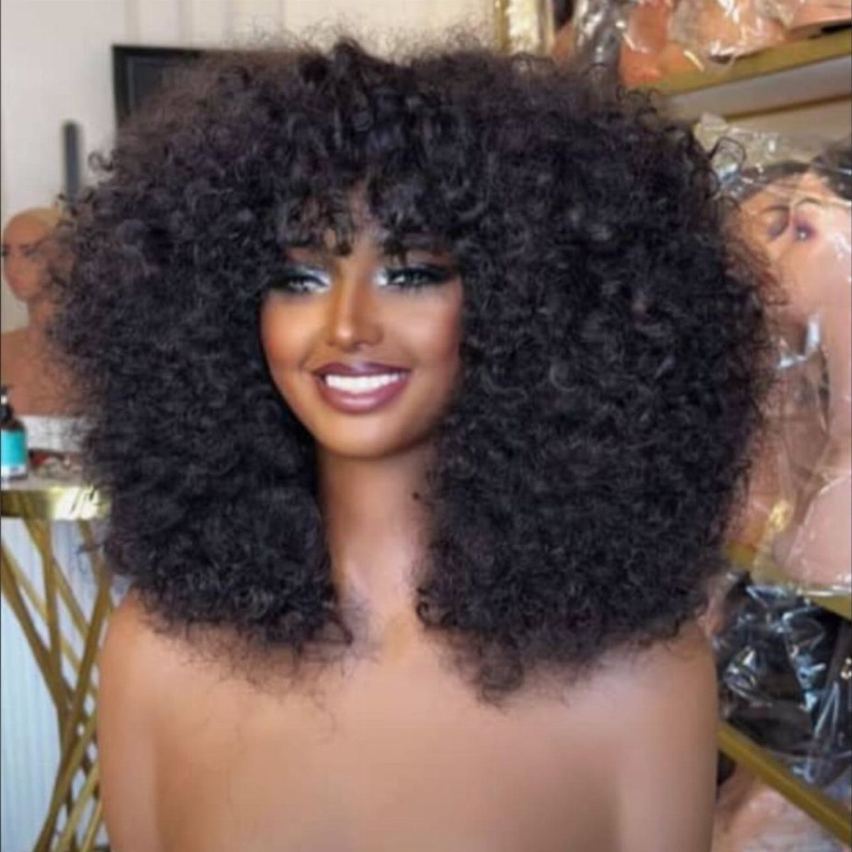 Woman with voluminous black curls and a thick, full fringe