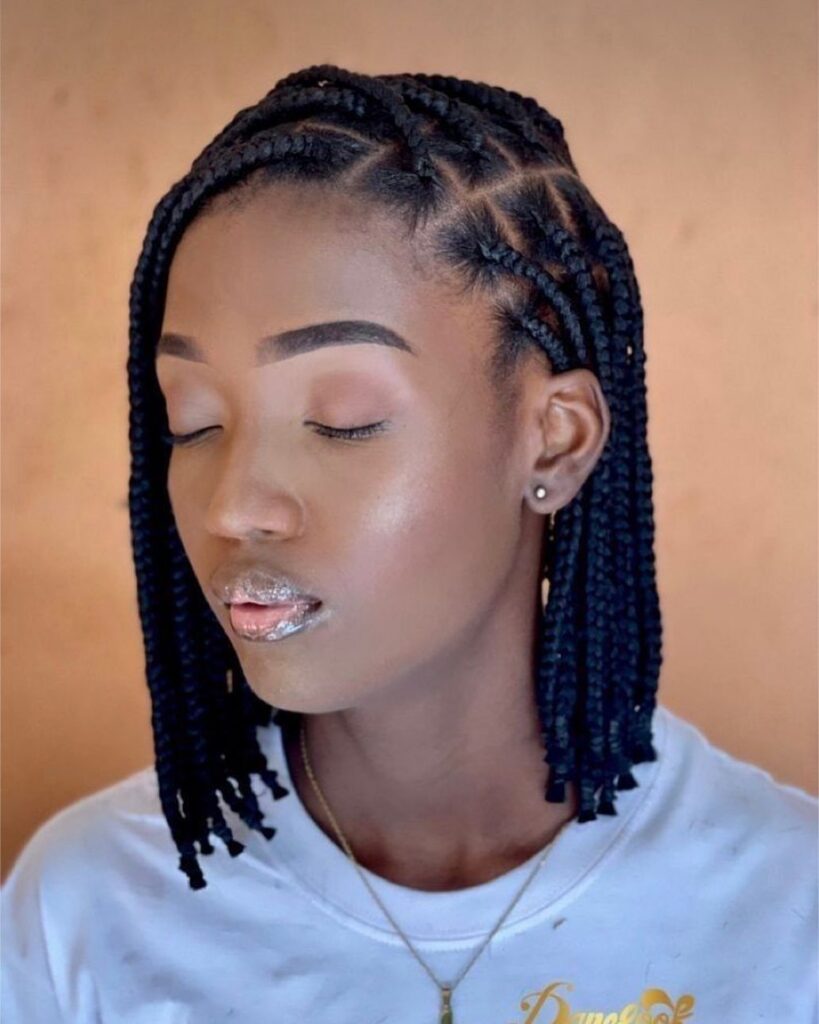 Short scalp-hugging braids curve into neat shoulder-length rows on a woman