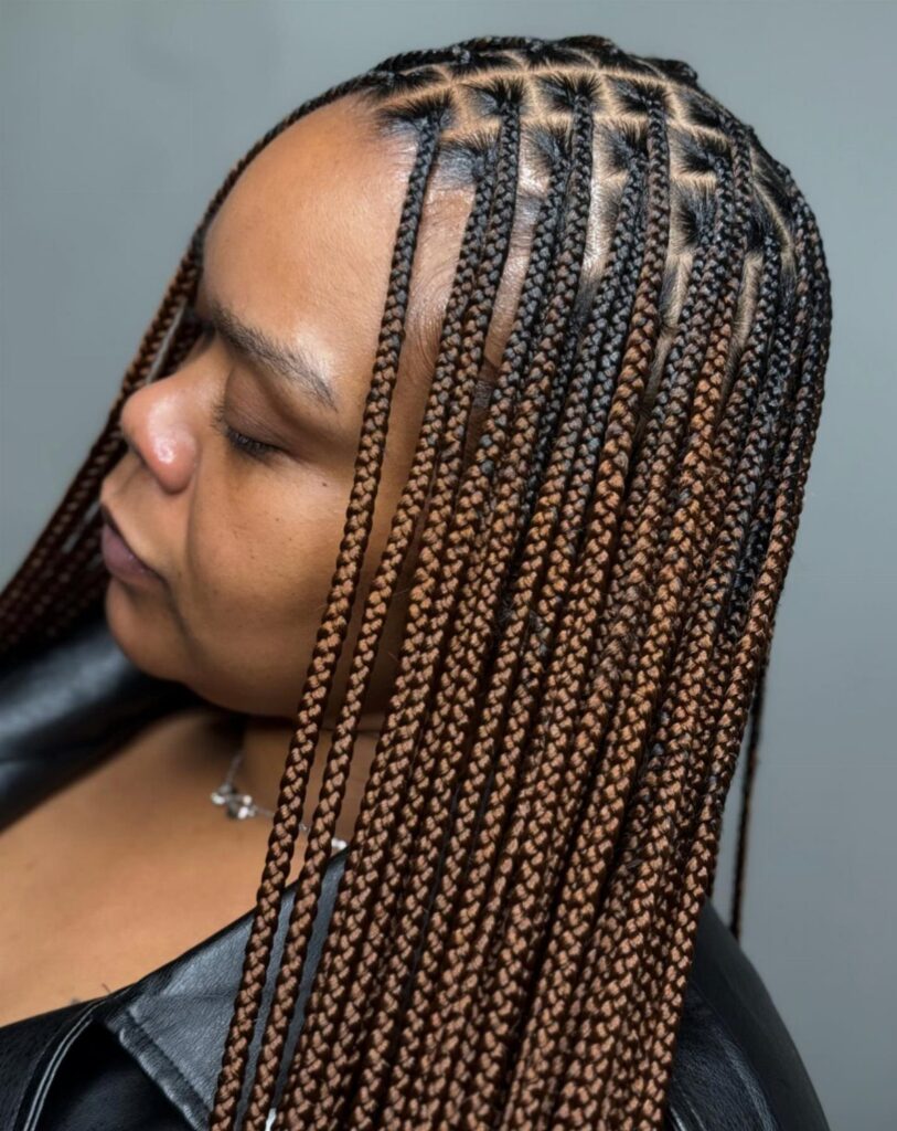 Long small knotless braids with neat scalp parting and brown highlights