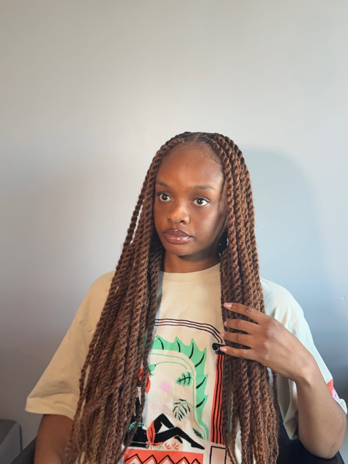 Woman with long brown Marley twists touching her hair